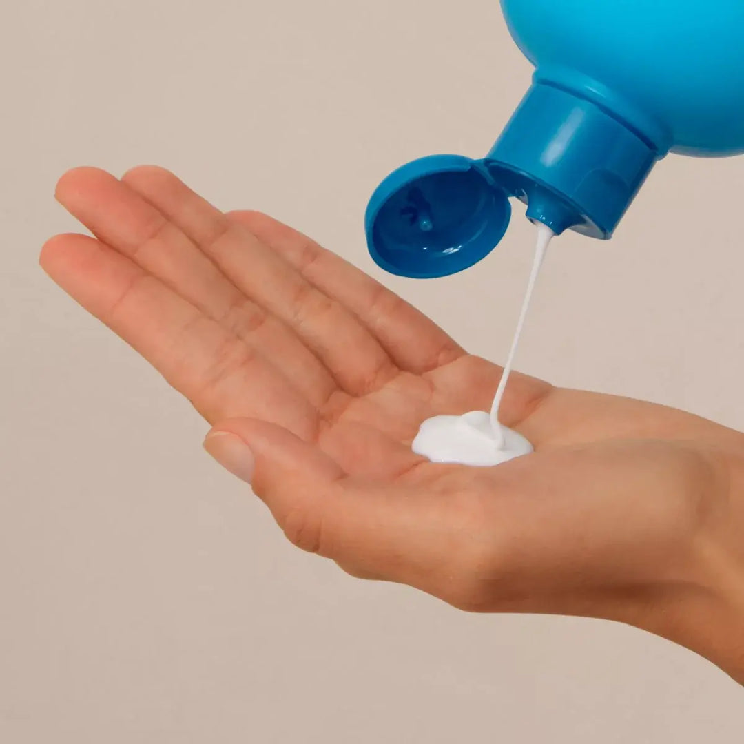 ISDIN Nutratopic Pro-Amp emollient bath gel being poured onto hand for atopic skin care