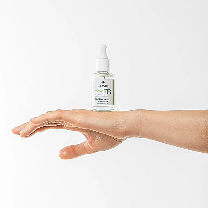 Hand holding a bottle of Elastin PB serum against a white background