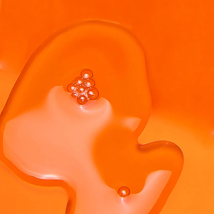 Orange abstract art with a cluster of small round objects on an orange background