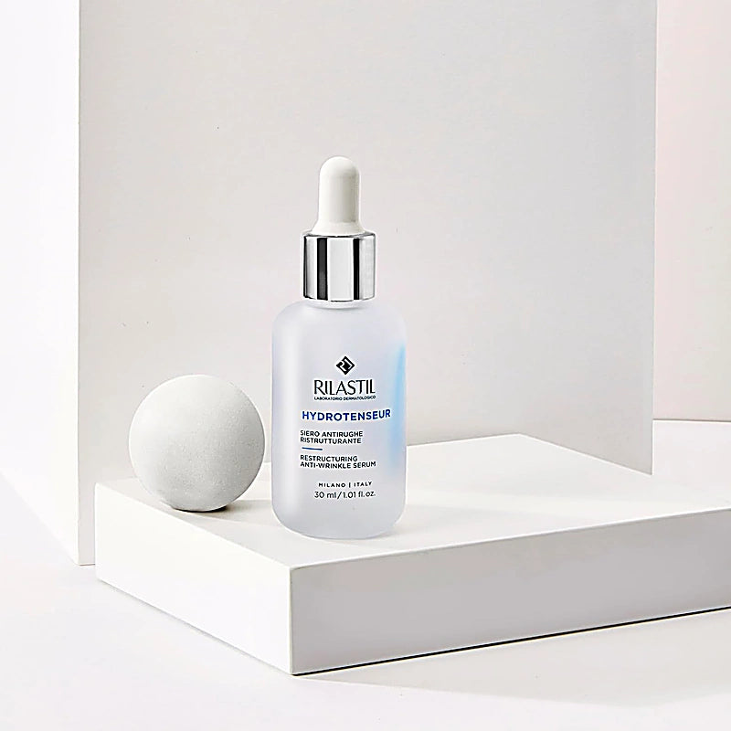 Rilastil skincare serum bottle on a white surface with a neutral background