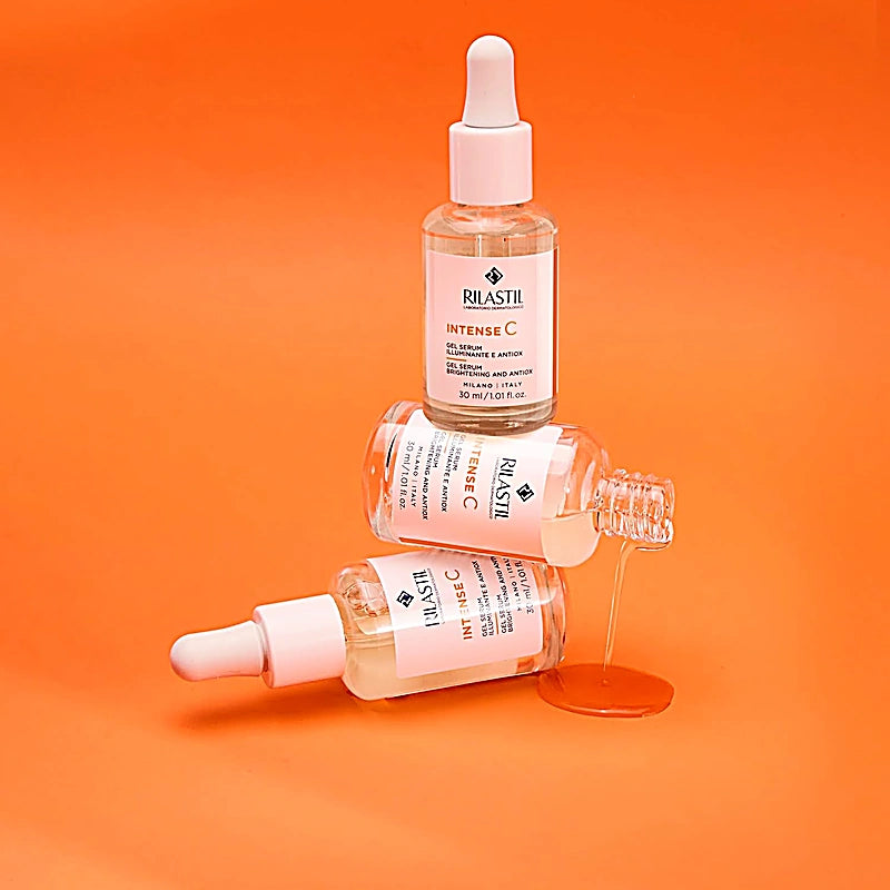 Three Rilastil skincare serum bottles on an orange background1