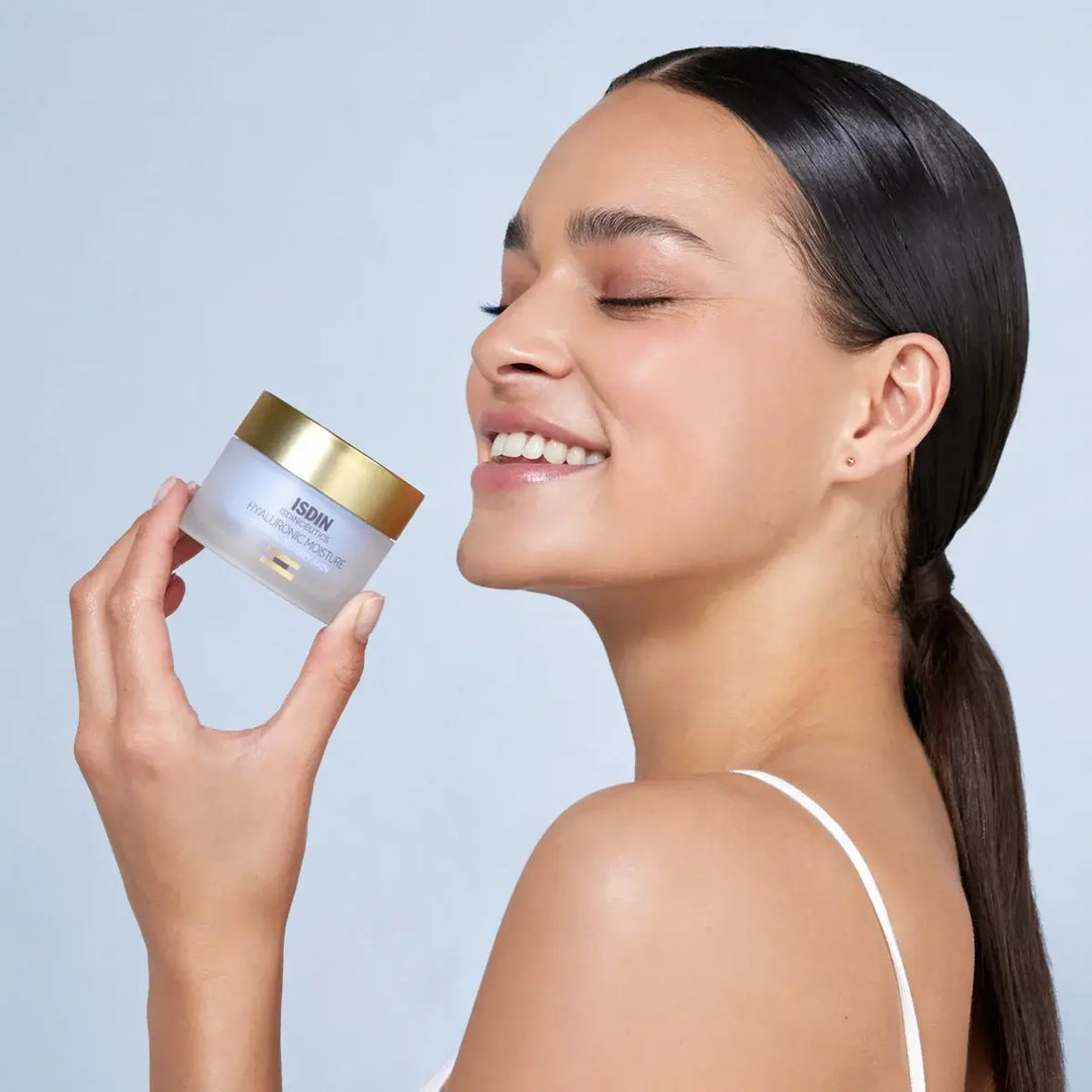 Woman holding ISDINCEUTICS Hyaluronic Moisture Cream for normal to dry skin with radiant complexion