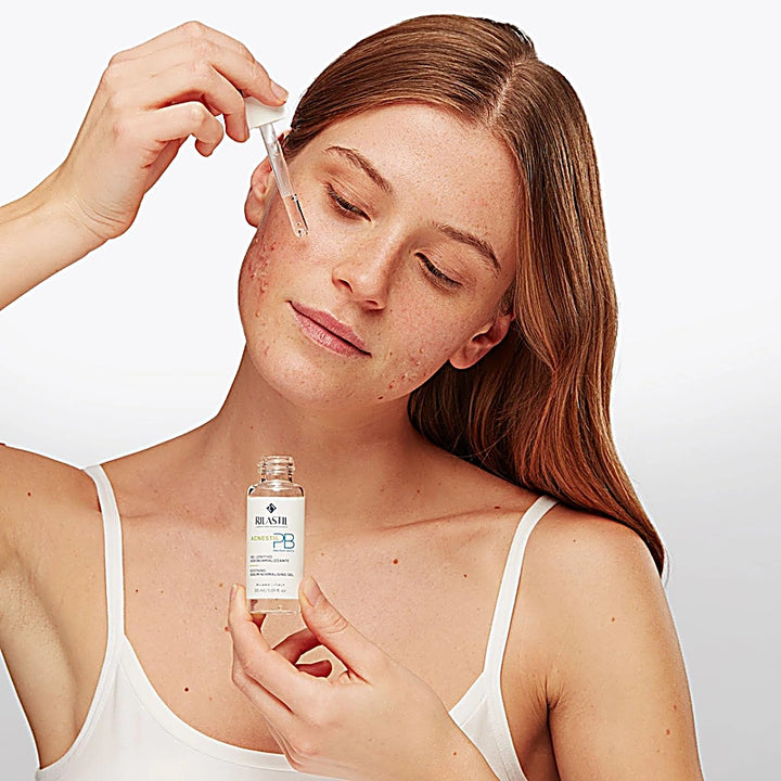Woman applying skincare product to her face with a dropper